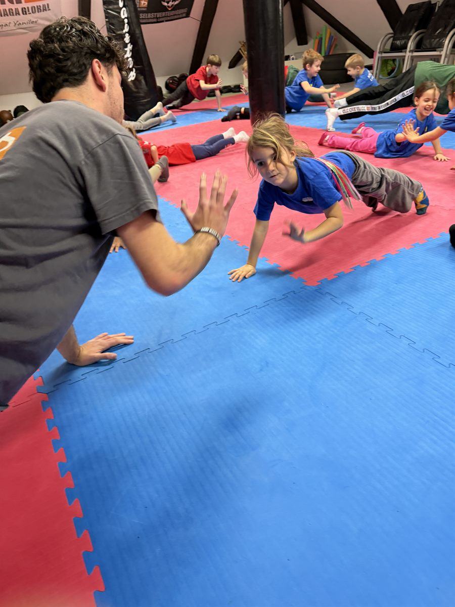 Trainer gibt einem Kind beim Training ein High-Five